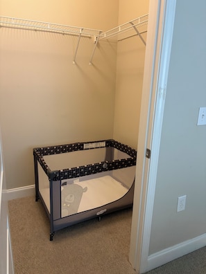 A room with a corner crib, a white door, and a wall-mounted shelf. - Relax In Style  ,Cozy. Modern Condo (Atlanta)