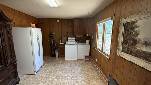 Cocina compacta con refrigerador, estufa y lavadora.