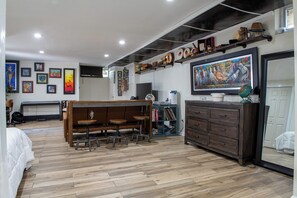A room with a wooden dining table, a television, and various wall-mounted items. - Near NYC & Metro-North! Private Yonkers Studio (Yonkers)