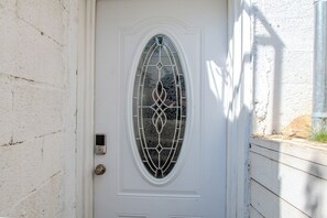 A white door with a decorative glass panel and a keypad lock.