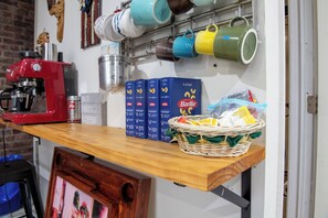 A kitchen counter with a coffee machine, Barilla pasta boxes, and a basket of snacks.