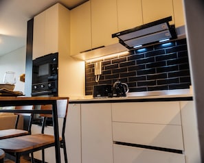 Una cocina moderna con microondas, cafetera y un salpicadero de ladrillo.