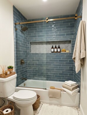 A bathroom with a shower, toilet, and bathtub. - Bluff Park Oasis (Long Beach)