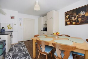 Una cocina compacta con comedor, microondas y un cuadro en la pared.