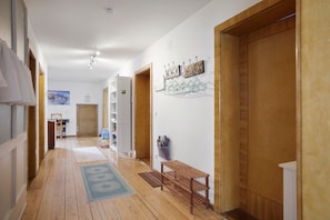 A hallway with wooden flooring, a bench, a coat rack, and a door. - Pet-Friendly Apartment in Historic Tanner’s House with Private Terrace in the Allgäu (Memmingen)