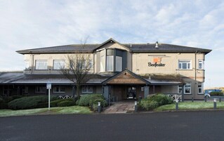 A two-story building with a sign reading 'Beefeater The Newhouse.'
