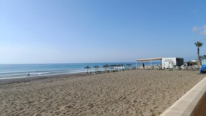 A beach with a covered seating area, umbrellas, and a sign that reads 'Sabor Tropical.' - Sun & Beach Apartment 805 (Province of Málaga)