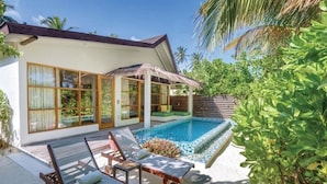 Une maison moderne dotée d’une piscine, de grandes fenêtres et d’une toiture en chaume.