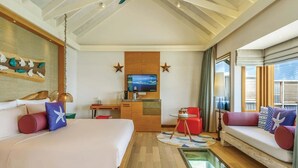 Une chambre d’hôtel comprenant un lit, un canapé, un bureau avec une télévision et un balcon avec vue.