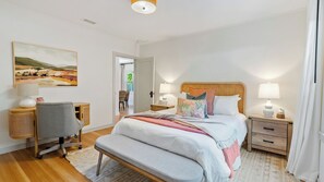 A bedroom with a bed, bedside tables, a chair, a rug, and a painting on the wall. - Lavender Porch by Avantstay Designer Bungalow + Fire Pit Near Downtown, Paso (Paso Robles)