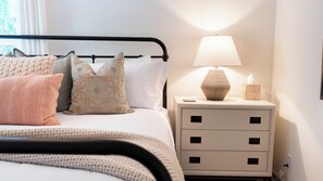 A neatly made bed with decorative pillows, a bedside lamp, and a small bedside table with a tissue box. - Lavender Porch by Avantstay Designer Bungalow + Fire Pit Near Downtown, Paso (Paso Robles)