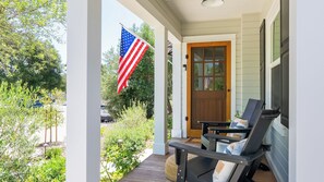 A porch with two chairs, an American flag, and a wooden door. - Lavender Porch by Avantstay Designer Bungalow + Fire Pit Near Downtown, Paso (Paso Robles)