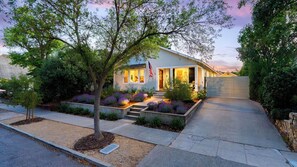 A residential house with a front porch, a flag, and a landscaped garden. - Lavender Porch by Avantstay Designer Bungalow + Fire Pit Near Downtown, Paso (Paso Robles)