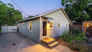 A single-story house with a front door, a small porch, and a backyard with plants. - Lavender Porch by Avantstay Designer Bungalow + Fire Pit Near Downtown, Paso (Paso Robles)