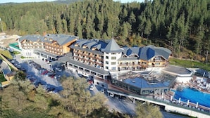 Ett hotell med flera våningar, ett poolområde och en skidlift som syns i bakgrunden.