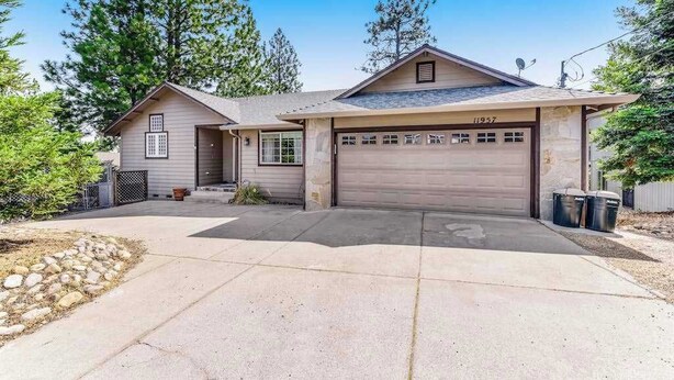 Einbungalow mit Garage, Veranda und Auffahrt.