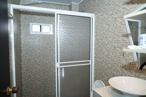 A bathroom with a shower enclosure, a sink, and a mirror. - Jhonny Cay Suites (San Andrés)