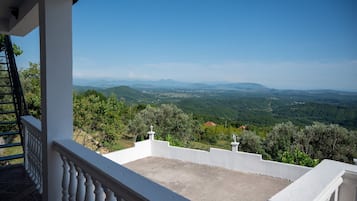 Ein Balkon mit Blick auf eine hügelige Landschaft.