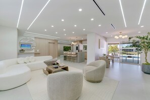 A modern living room with a sofa, armchairs, and a coffee table. - Lux Escape Cape Coral (Cape Coral)