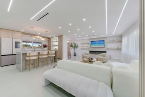 Ein modernes Wohnzimmer mit Küche, Bar und Sitzgelegenheit.