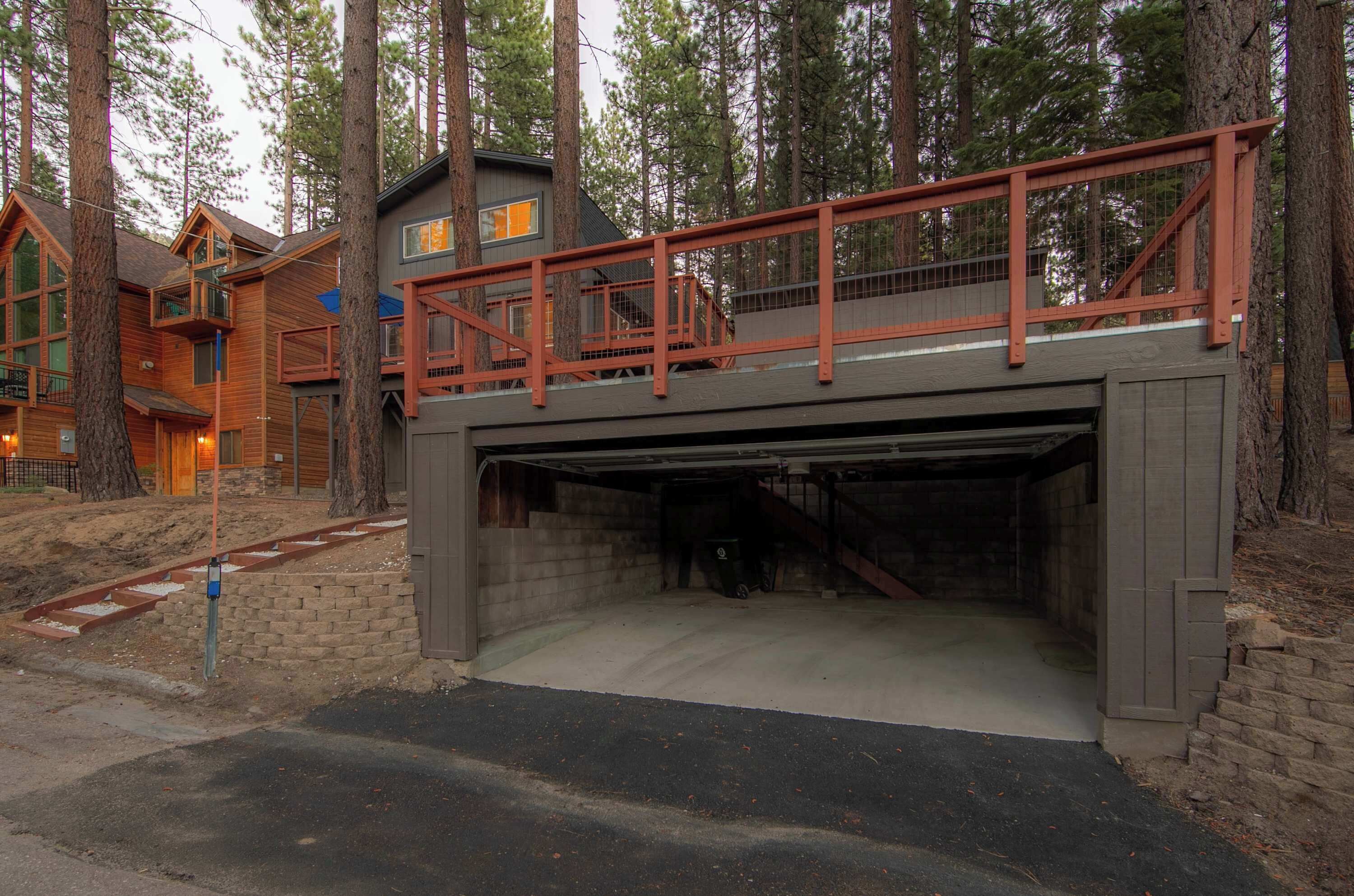 A multi-level building with a covered garage entrance, surrounded by trees.