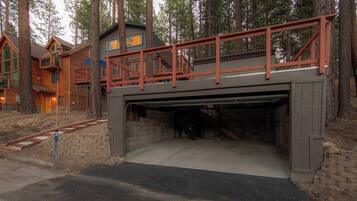 A multi-level building with a covered garage entrance, surrounded by trees.