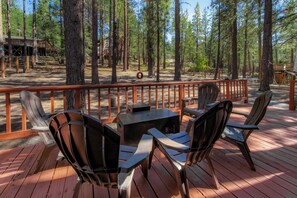 A deck with outdoor furniture, surrounded by a wooden railing and tall trees. - Tree Top Verdon - 5bdr With Sauna (South Lake Tahoe)
