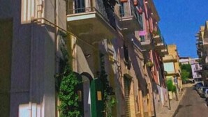 Een straat met een gebouw, een bord met de tekst 'il piccolo Albergo'.