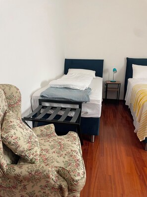 A room with a bed, a chair, a small table, and a nightstand. - Near Me:Mansio Portus,Civitavecchia, Railroad,Port, Cruise Ships,Rome,Etruscans (Civitavecchia)