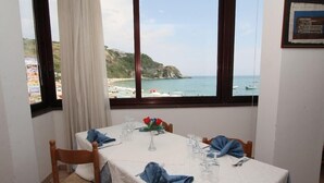 Mesa de comedor para cuatro con vista al mar y un acantilado.