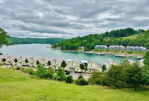 A lakeside property with multiple houses, a dock, and a boat. - The Lili Pad - Modern Lakefront Condo w/ Boat Slip and Breathtaking Views (LaFollette)