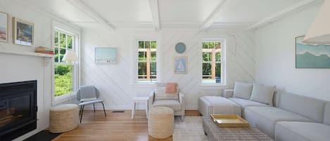 A room with a fireplace, a sofa, a coffee table, and a television.