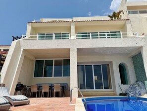 Un bâtiment à deux étages doté d’une piscine, d’un espace extérieur aménagé et d’un balcon.