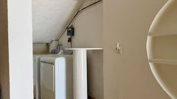 A laundry room with a washing machine, a dryer, and a utility wall with electrical outlets.