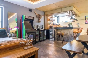 Ein modernes Hotelzimmer mit Barbereich, Holzmöbeln und einem dekorativen Büffel Schädel.