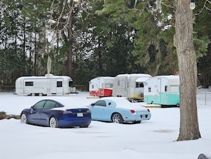 A parking area with snow-covered cars and vintage trailers. - Vintage Shasta, Glamping for two near Savannah, Hinesville, and Beaches (Midway)