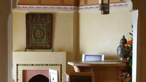 A room with a fireplace, a desk with a laptop, and a chair. - Le Pavillon Du Golf (Marrakech)
