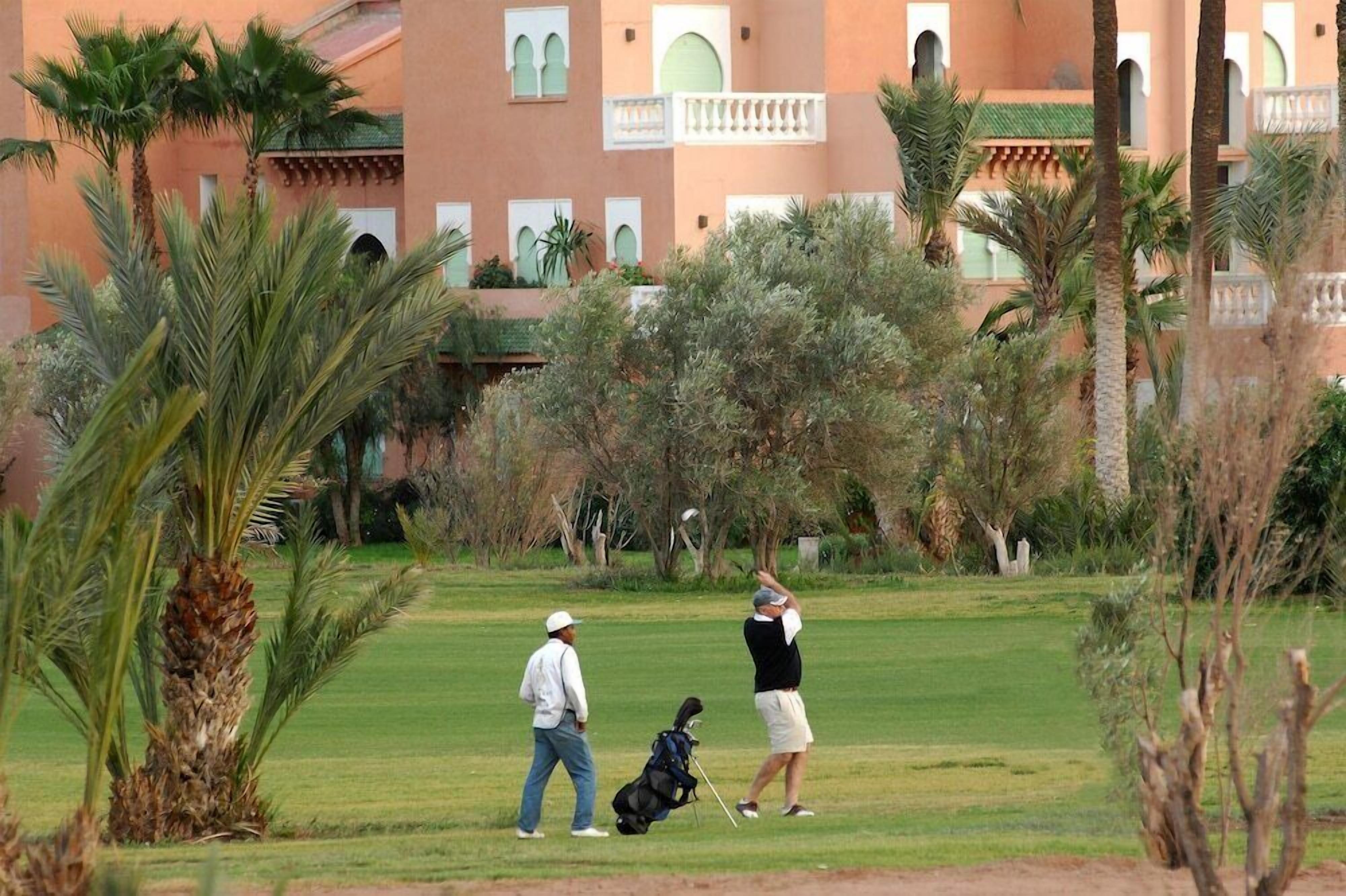 Un campo de golf con un edificio al fondo.