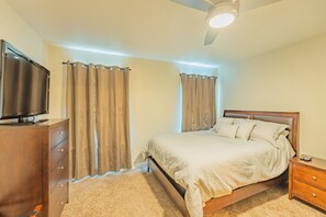 A bedroom with a bed, a TV on a dresser, and a ceiling fan. - Serene Rustic Getaway (Converse)