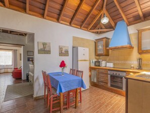A kitchen with wooden cabinets, a dining table with chairs, a refrigerator, and a microwave. - CHL Basilisa Capote traditional House (El Paso)