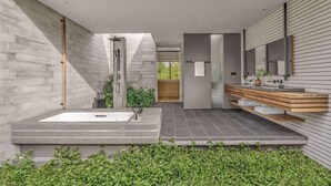 Une salle de bain moderne avec une grande baignoire, une douche et un meuble-lavabo en bois doté d’un miroir.