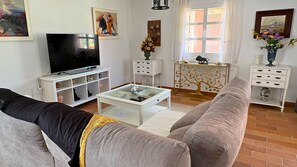 A living room with a television, sofas, a coffee table, and decorative items.
