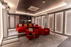 Un salon moderne avec un canapé d’angle, une cheminée et une grande fenêtre.