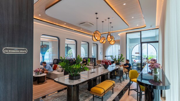 A modern co-working space with a long communal table, individual seating, and large windows. - The Title Legendary Designer 2BR near Bang Tao Beach (Tambon Choeng Thale)