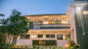 Ein zweistöckiges Gebäude mit Balkon, mehreren Fenstern und Außenbeleuchtung.