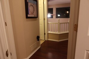 A hallway with a door leading to a room with a window and a light fixture. - Updated Modern 3-Bedroom Home with Private Hot Tub (Littleton)
