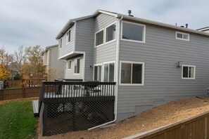 A two-story residential building with a covered patio area. - Updated Modern 3-Bedroom Home with Private Hot Tub (Littleton)
