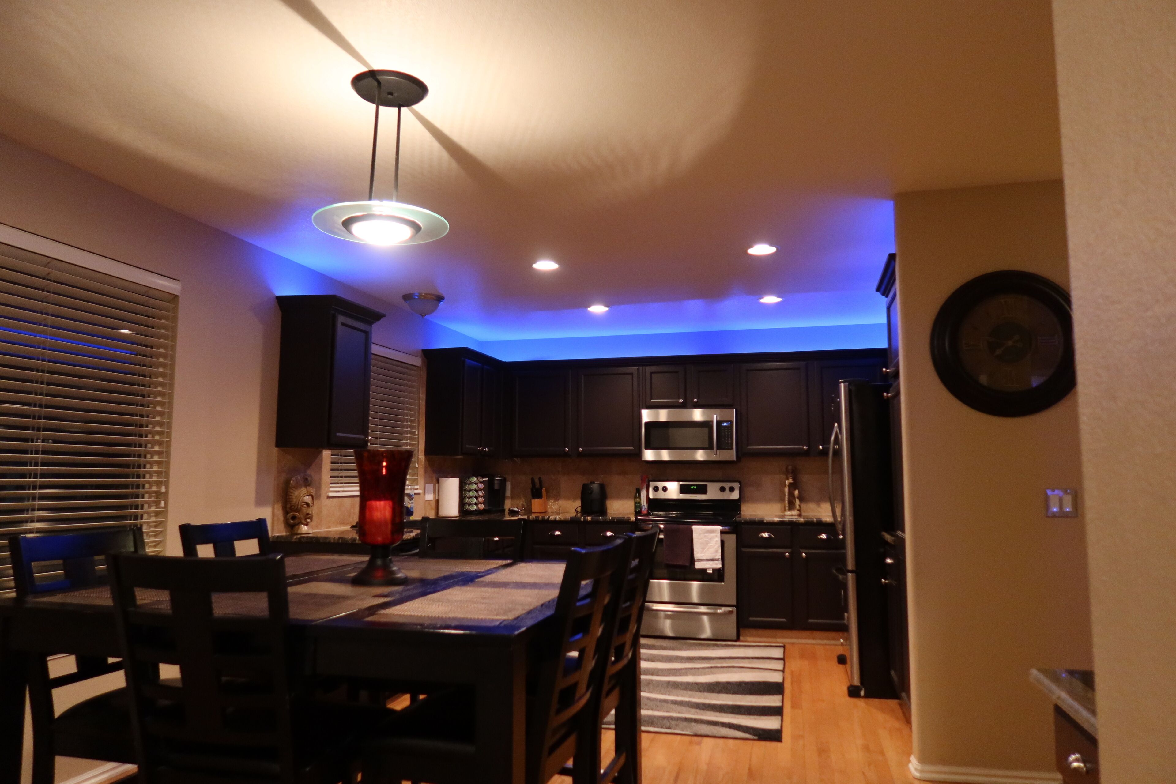 A modern kitchen with dark cabinets, a stainless steel microwave, and an oven.