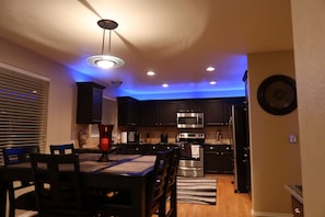 A modern kitchen with dark cabinets, a stainless steel microwave, and an oven. - Updated Modern 3-Bedroom Home with Private Hot Tub (Littleton)