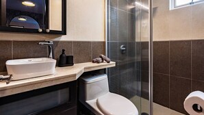 A modern bathroom with a white sink, a toilet, and a glass shower enclosure. - Designer Apt in Roma Norte, Parking & Workspace (Mexico City)